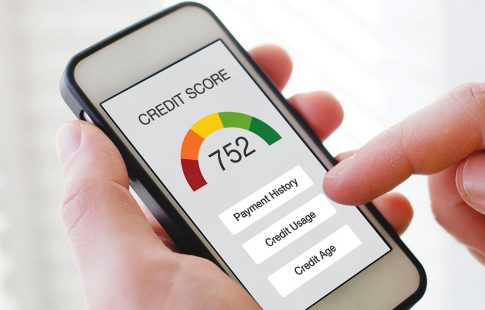 Man’s hand holding a smartphone showing a credit score as he checks to see if a soft credit check affected his credit score.