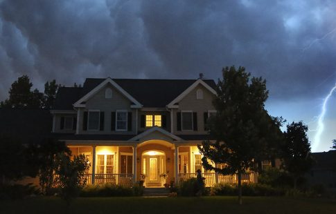 Lightning strikes behind a home