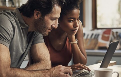 A couple looks at a laptop screen