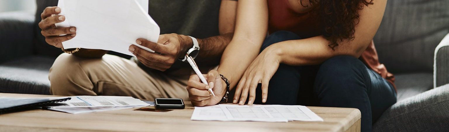 A couple works on paperwork at a coffee table