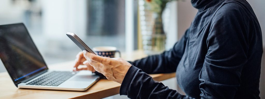 Woman sitting in front of a laptop, thinking about low down payment mortgage options