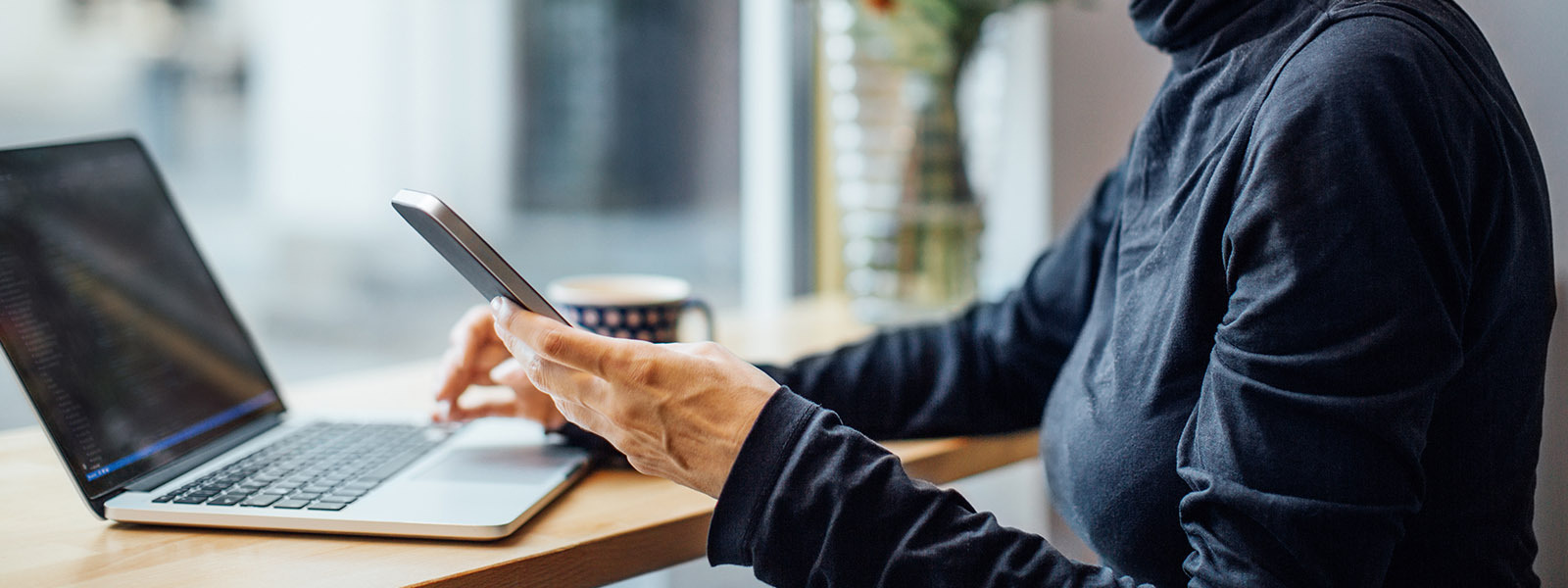 Woman sitting in front of a laptop, thinking about low down payment mortgage options