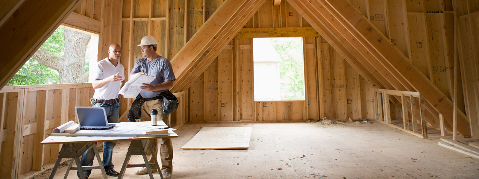 Two contractors talking in an unfinished attic