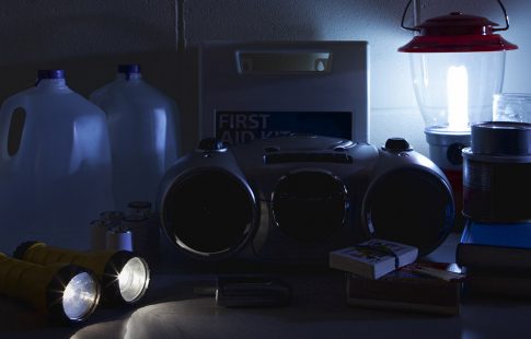 Emergency supplies including water bottles and flashlights sitting on a counter for winter weather emergency hacks