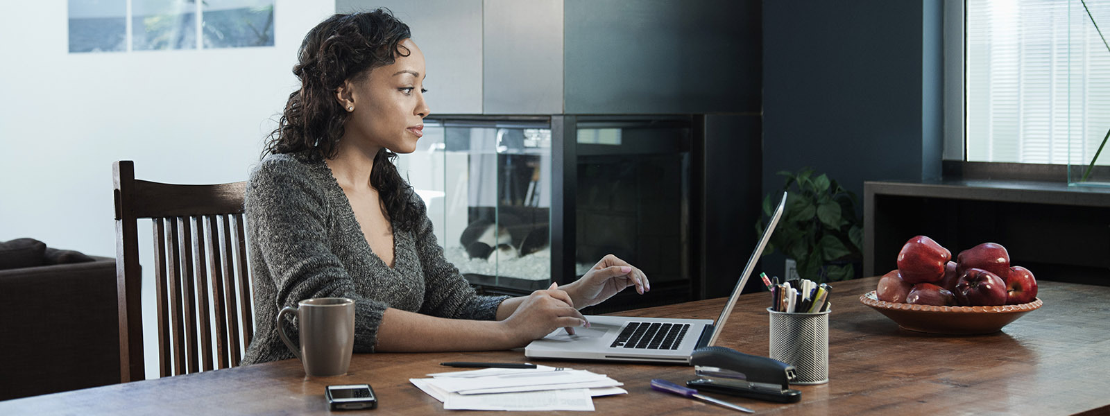 Woman using a laptop at a kitchen table