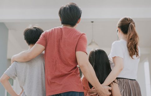 Family of four looking toward a house