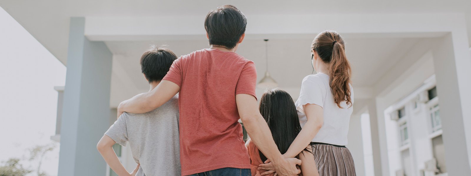 Family of four looking toward a house