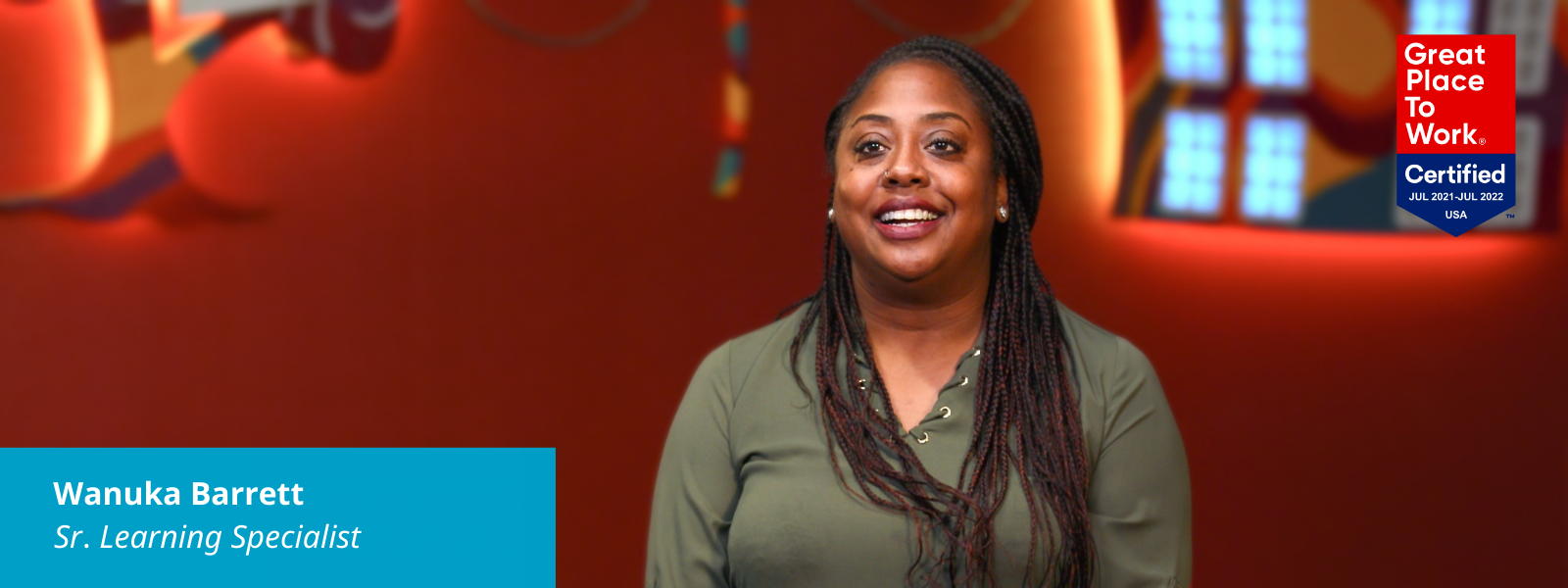 Wanuka discussing Black History Month. There's a Great Place to Work logo in the upper right corner of her picture and text in a blue box in the lower left corner: Wanuka Barrett, Sr. Learning Specialist