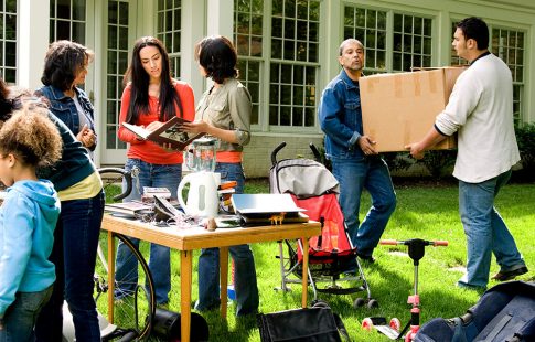 People shopping at a yard sale that can help reduce moving costs