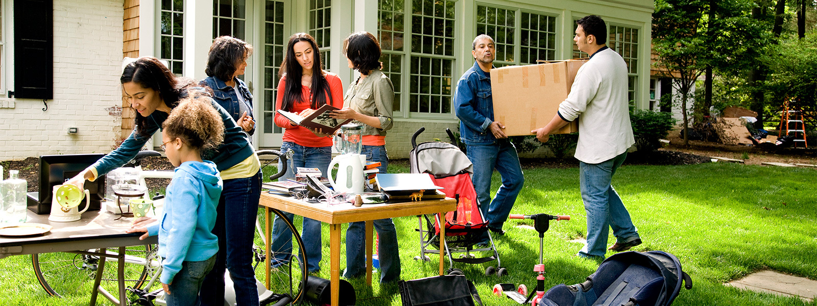 People shopping at a yard sale that can help reduce moving costs