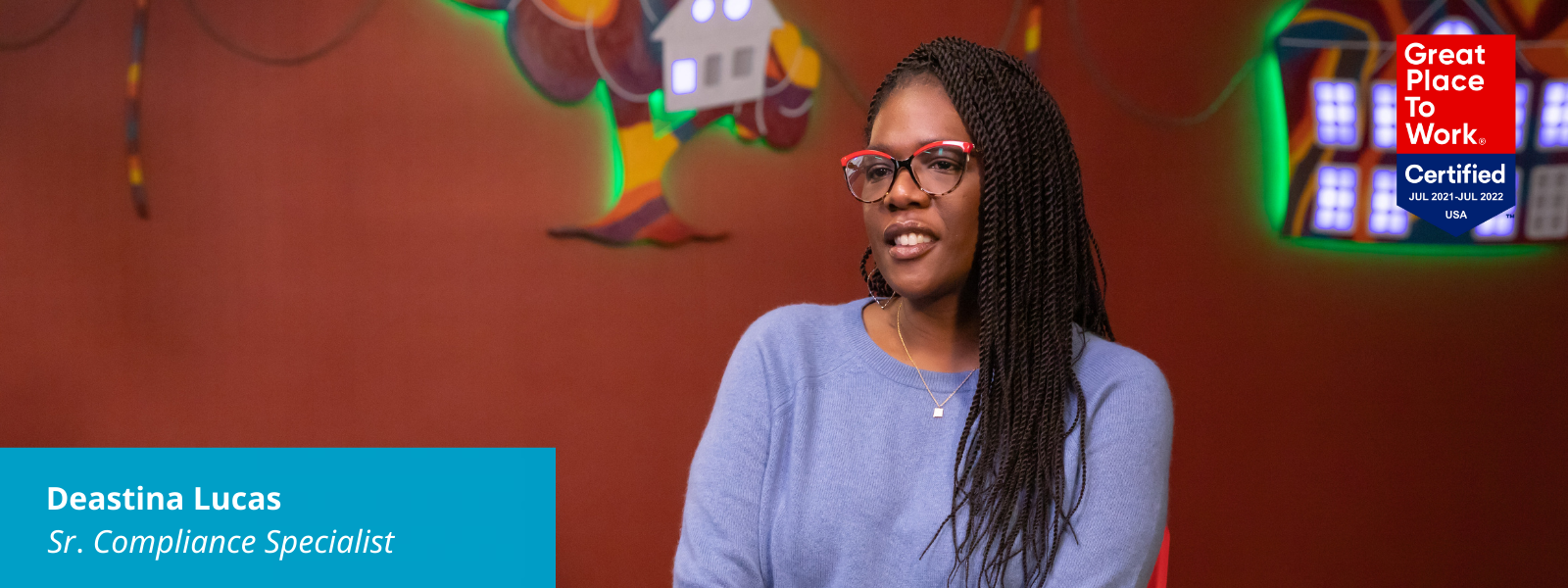 Deastina discussing Black History Month. There's a Great Place to Work logo in the upper right corner of her picture and text in a blue box in the lower left corner: Wanuka Barrett, Sr. Compliance Specialist