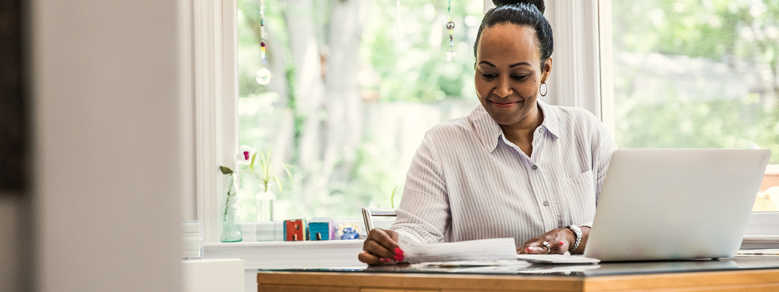 Women working at a kitchen table with a laptop and year-end mortgage tax paperwork