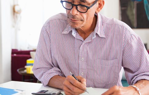 Man looking at a calculator as he considers, "When is a cash out refinance a good idea?"