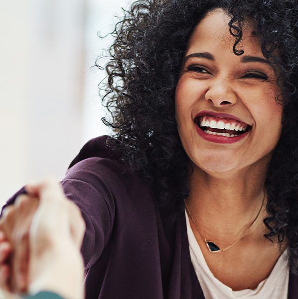 Smiling woman shaking hands with another woman after getting a mortgage with a new job