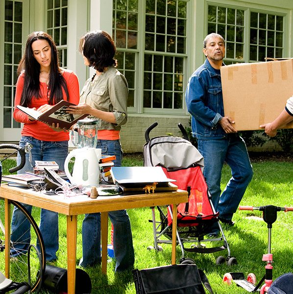 People shopping at a yard sale that can help reduce moving costs