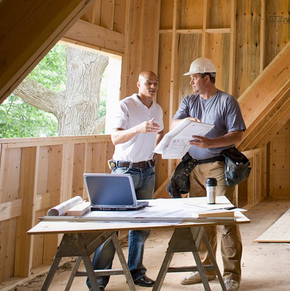 Two contractors talking in an unfinished attic