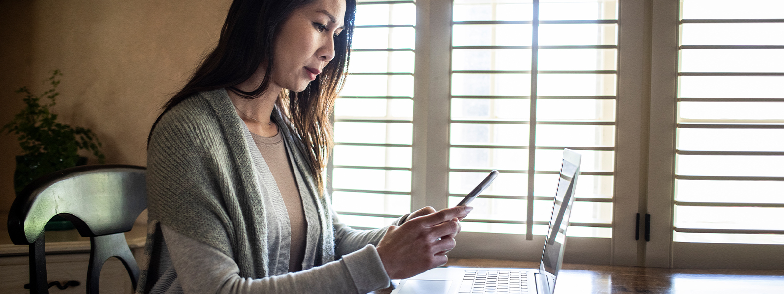 A woman with a concerned expression reads a text. Calls, texts, and emails can be quick and convenient, but they can also be a way for a mortgage scammer to steal your identity or money if your guard is down.