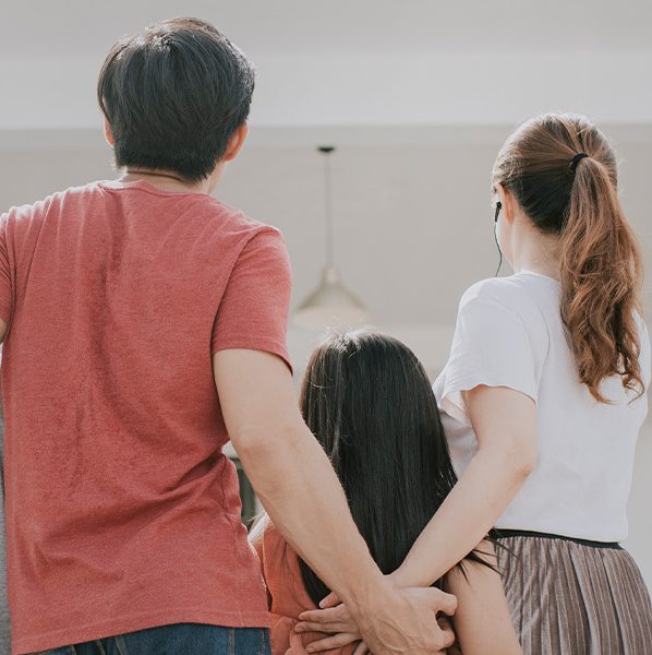 Family of four looking toward a house