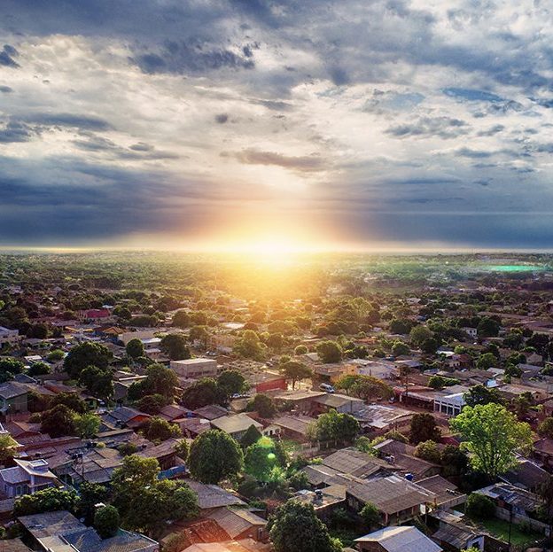 Picture of city of homes with sun rising in background