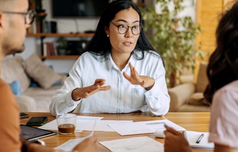 Woman sitting at a table with a couple explaining common mortgage terms