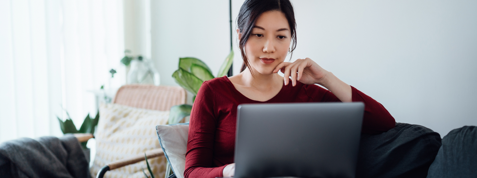 Woman wondering "Is Mr. Cooper a real mortgage company" reading an article on a laptop