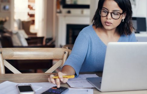 Woman working on a calculator after wondering, "what is escrow and how does it work?"