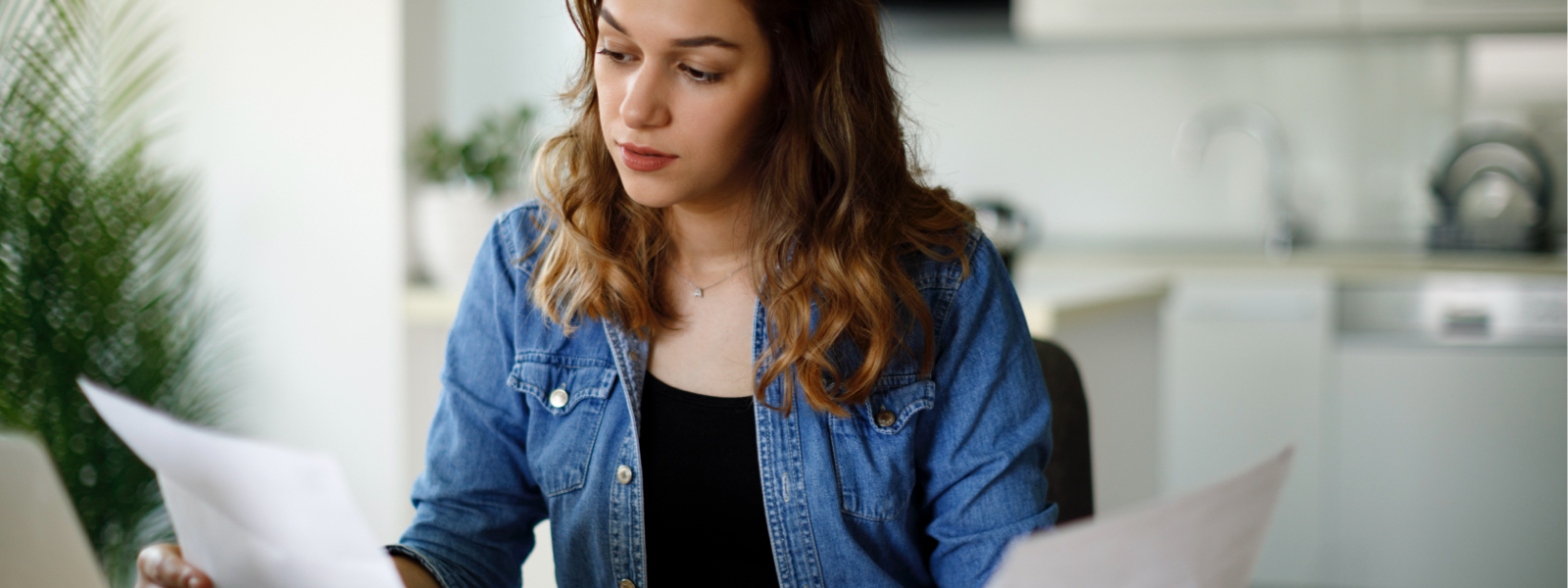 Women holding a piece of paper in each hand, deciding on a cash-out refinance vs. a home equity loan