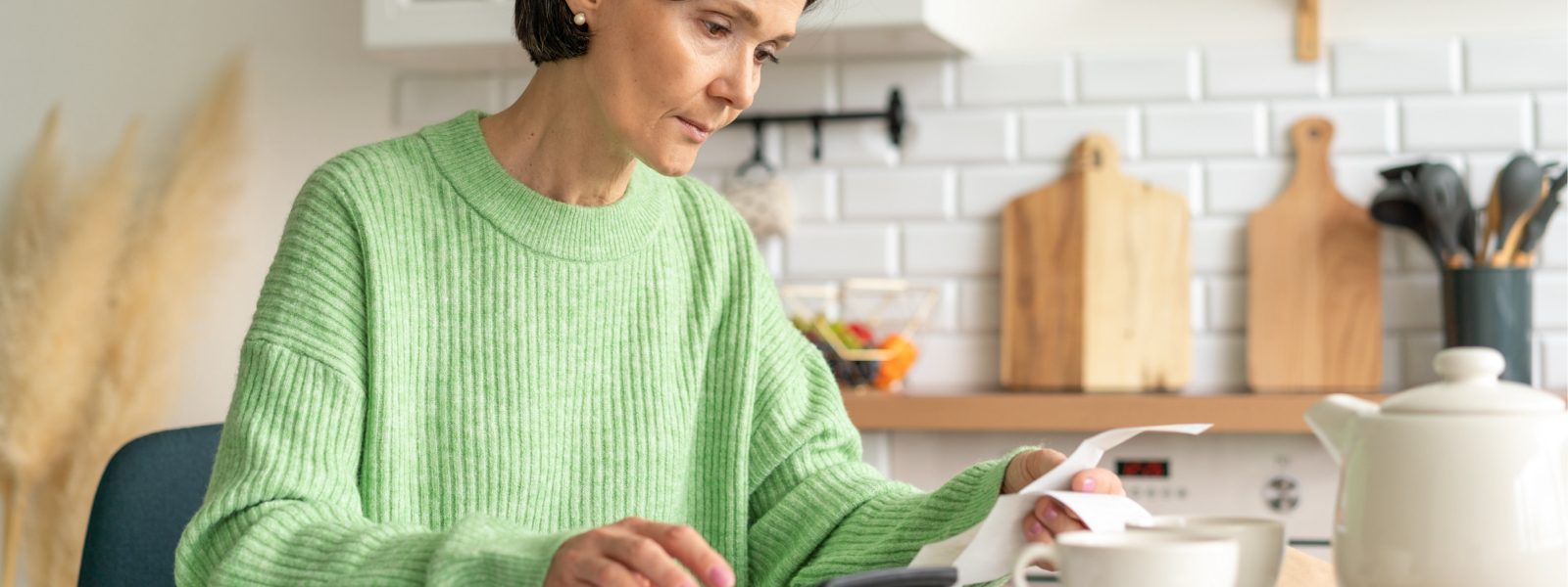 Woman in kitchen looking at receipts, wondering how to appeal a property tax assessment to save money